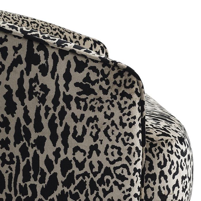 Detail of the Durban sofa: the leopard chenille wrapping its curved arm