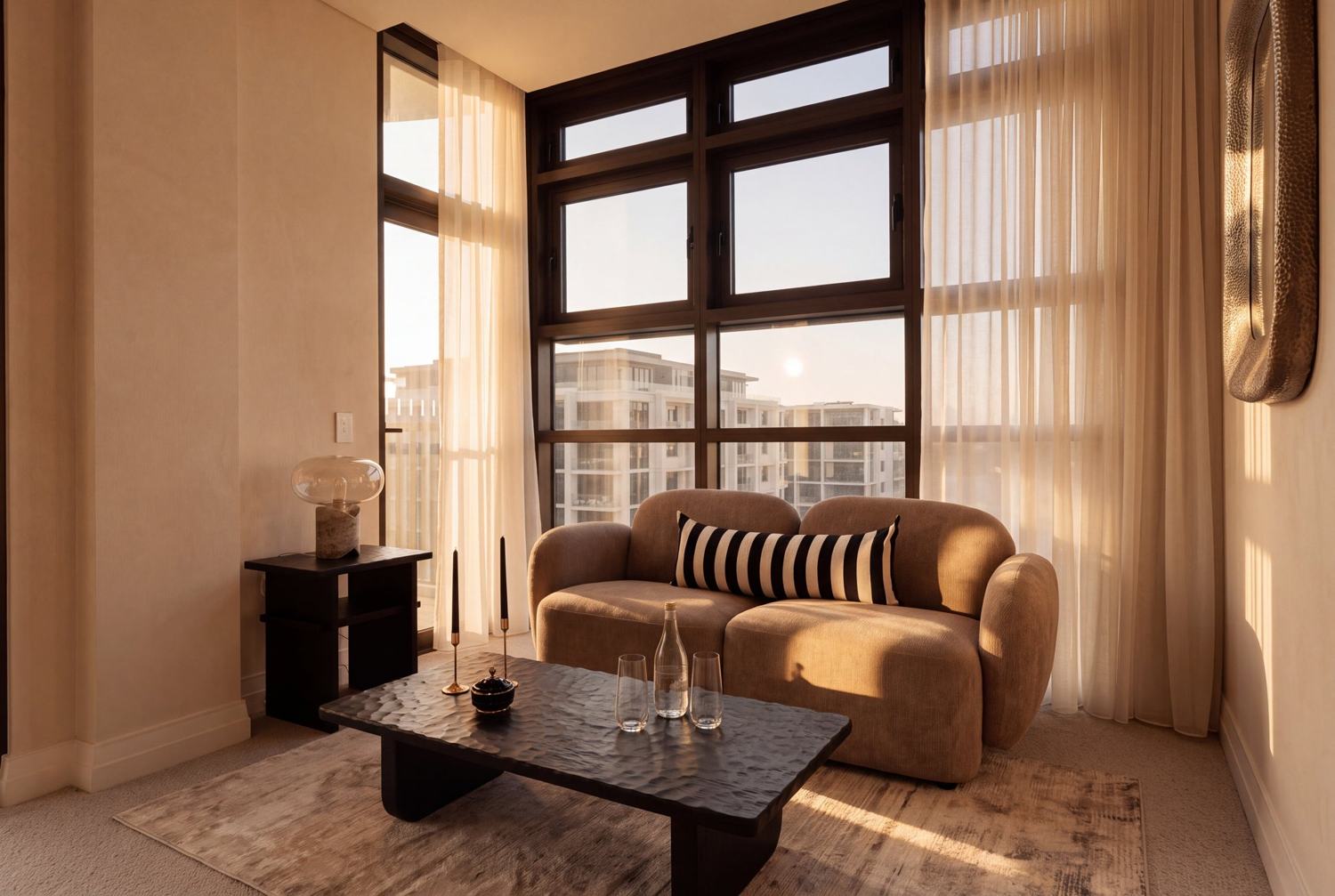 The curved Ramona sofa before tall windows at sunset