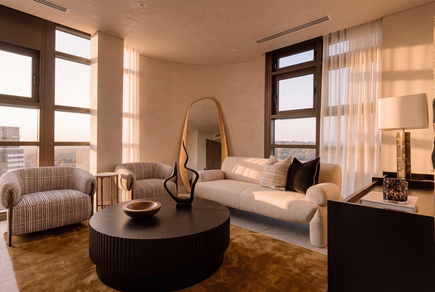 The media room at The Living Penthouse: the ivory Rachel sofa, Napa arm chairs and a black fluted Avery table at sunset